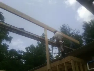 Carpenter setting a ridge beam over a new addition frame — Ice Dam Removal by Roofing Brothers in Ivoryton