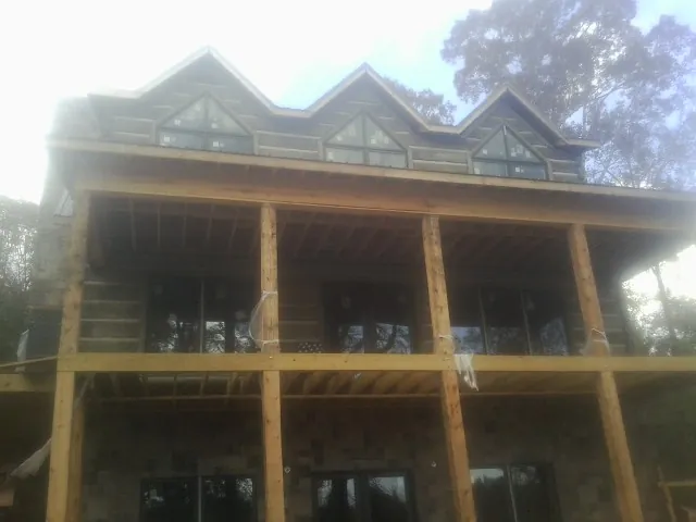 Dormers and porch framing on a large log home under construction — Roof Coating work by our crew in Ivoryton