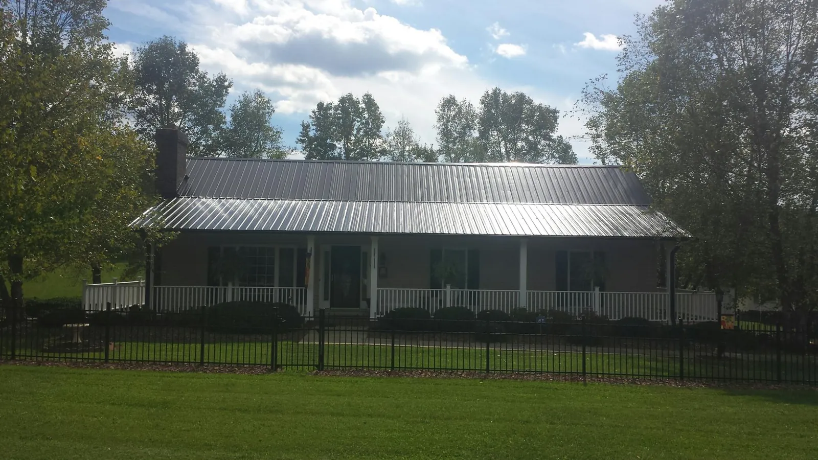 Gray metal roof on a brick ranch with a full width front porch — Gutter Guard Installation work by our crew in Ivoryton